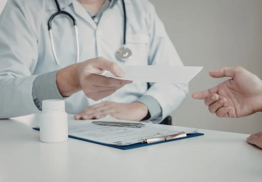 Mental health provider handing a prescription to a patient during a medication management appointment