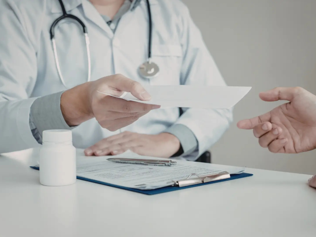 Mental health provider handing a prescription to a patient during a medication management appointment