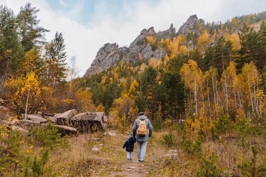 Parent hiking with child on a nature trail symbolizing guidance and navigating life transitions together