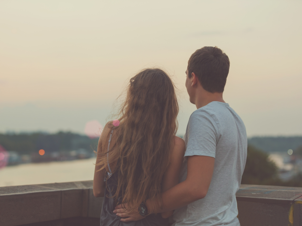 a couple looking over a lake