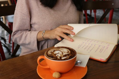 Woman journaling with coffee.