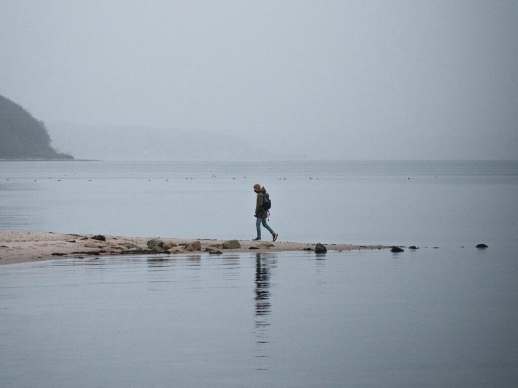 Man Walking in the water with a backpack
