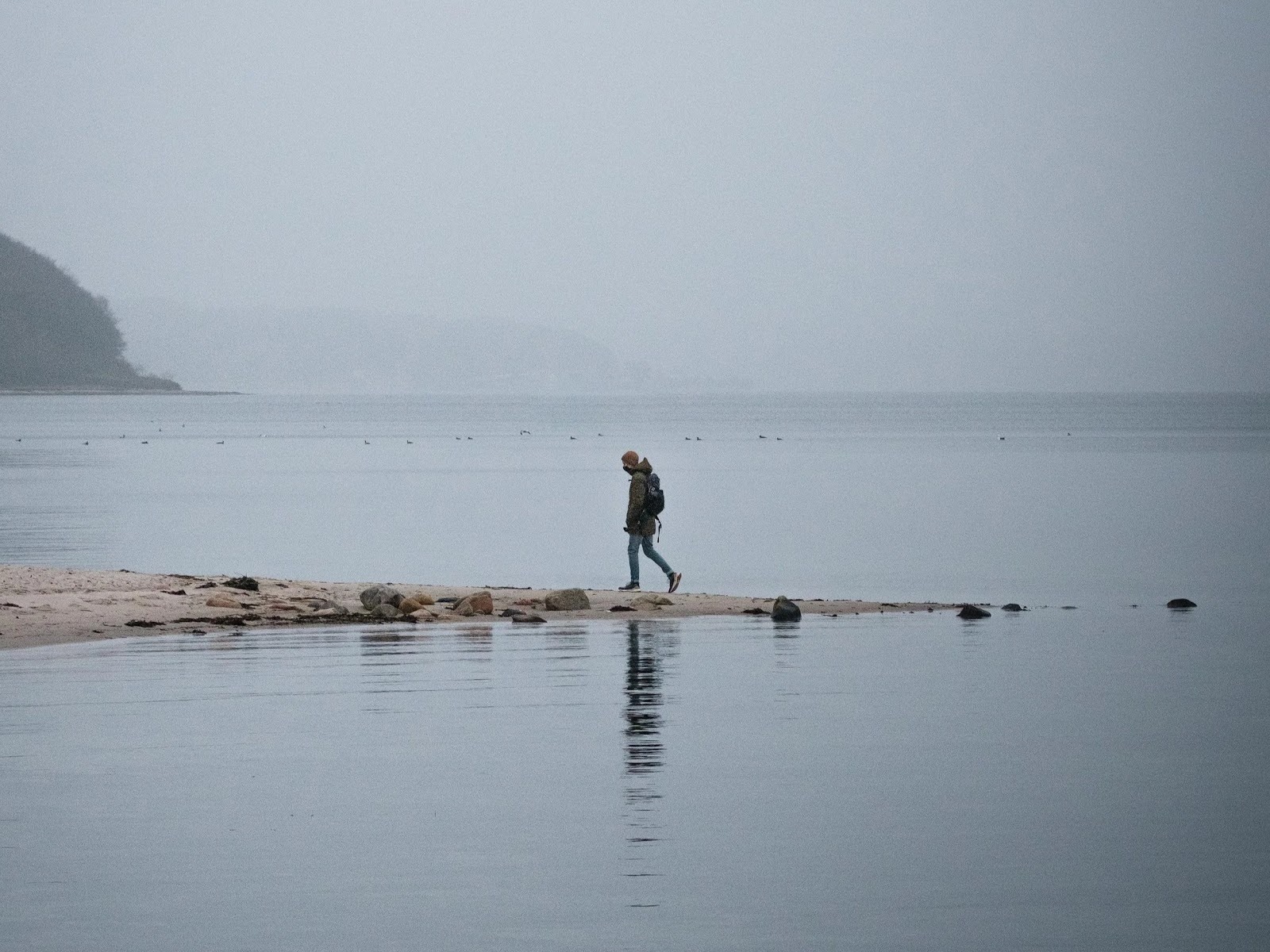 Man Walking in the water with a backpack