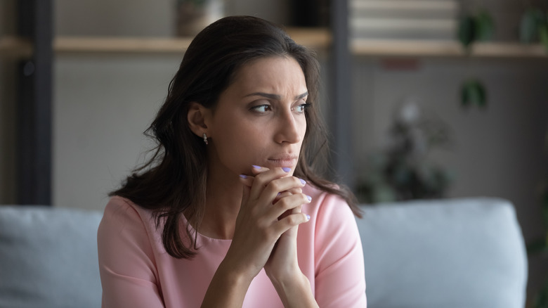 Woman sitting with hands by her face looking stressed
