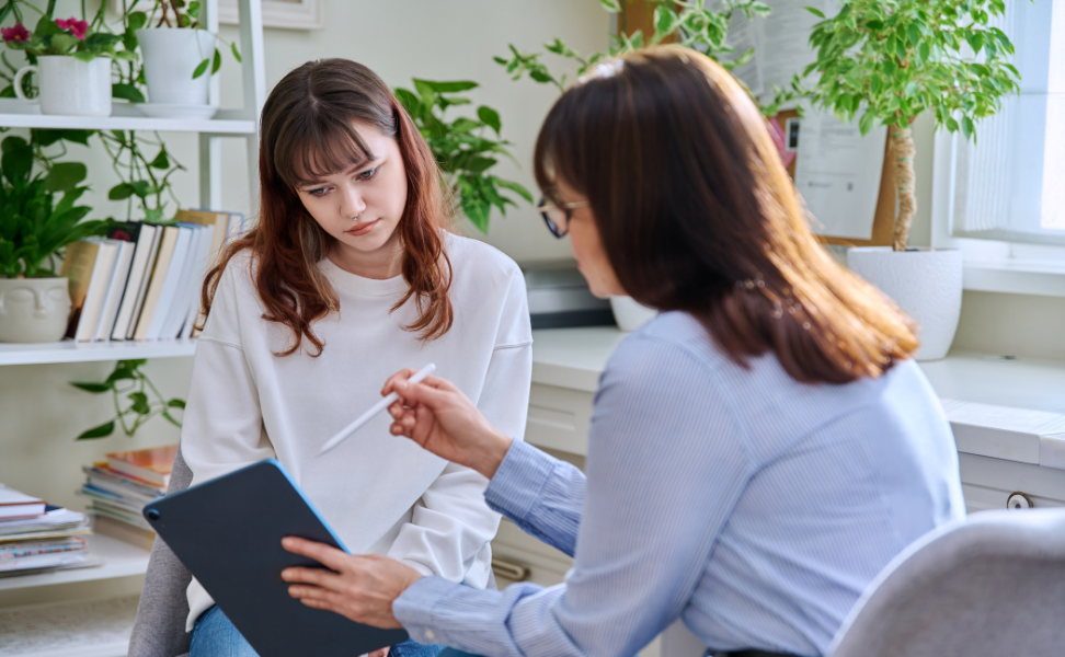 Two Woman talking in an office with a clip board