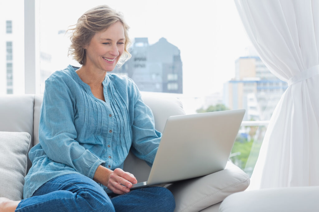 Woman on laptop with city in the background