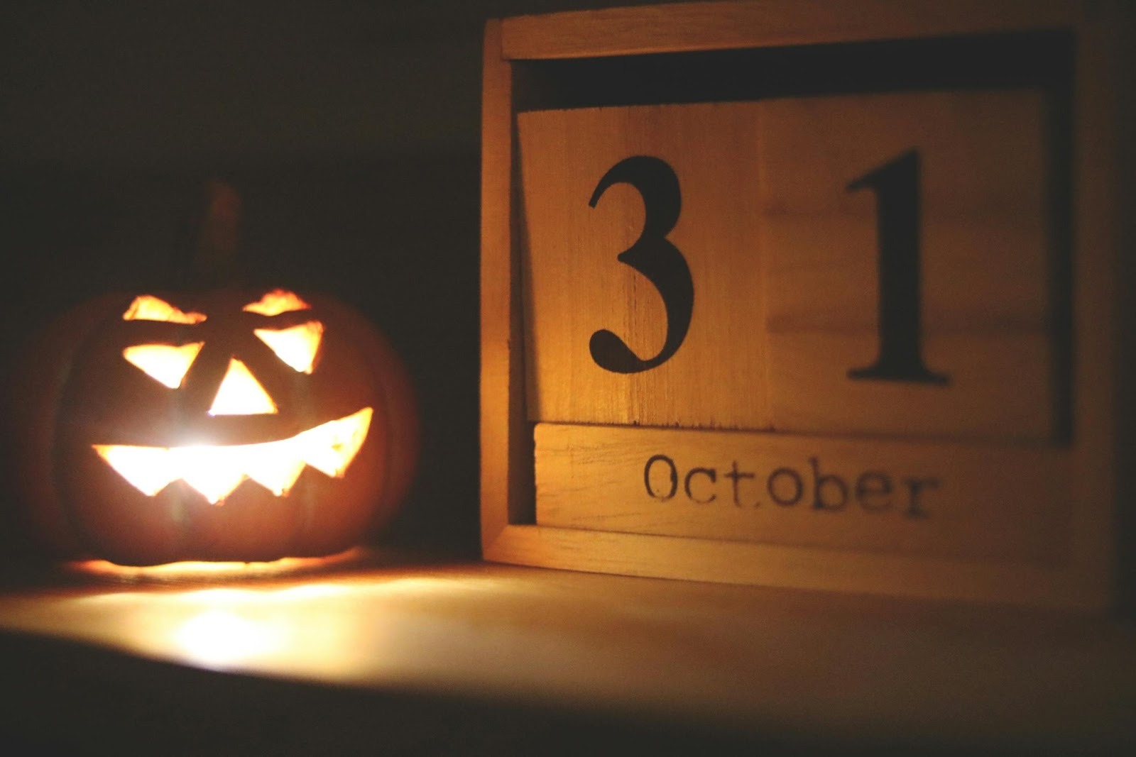 Jack o' lantern sitting next to a calendar