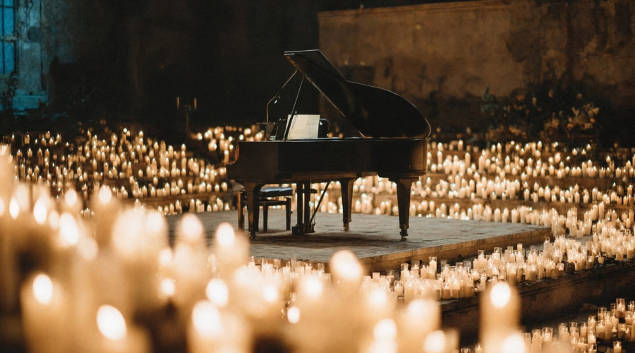 A grand piano surrounded by hundreds of candles, representing the big gestures that matter less than small daily acts of love