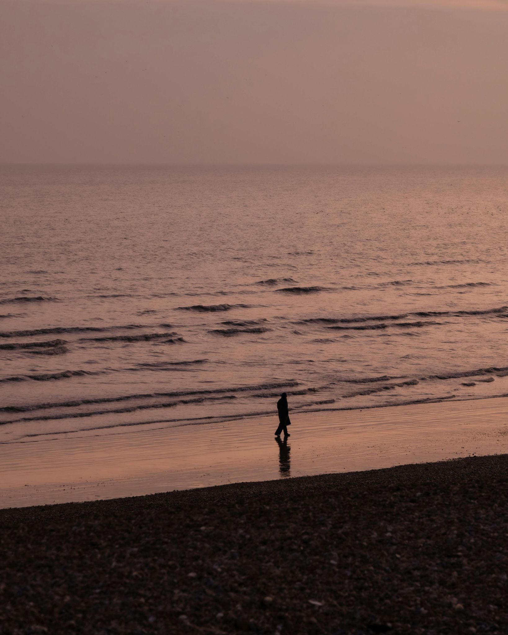 A person coping with summer grief alone near the ocean.