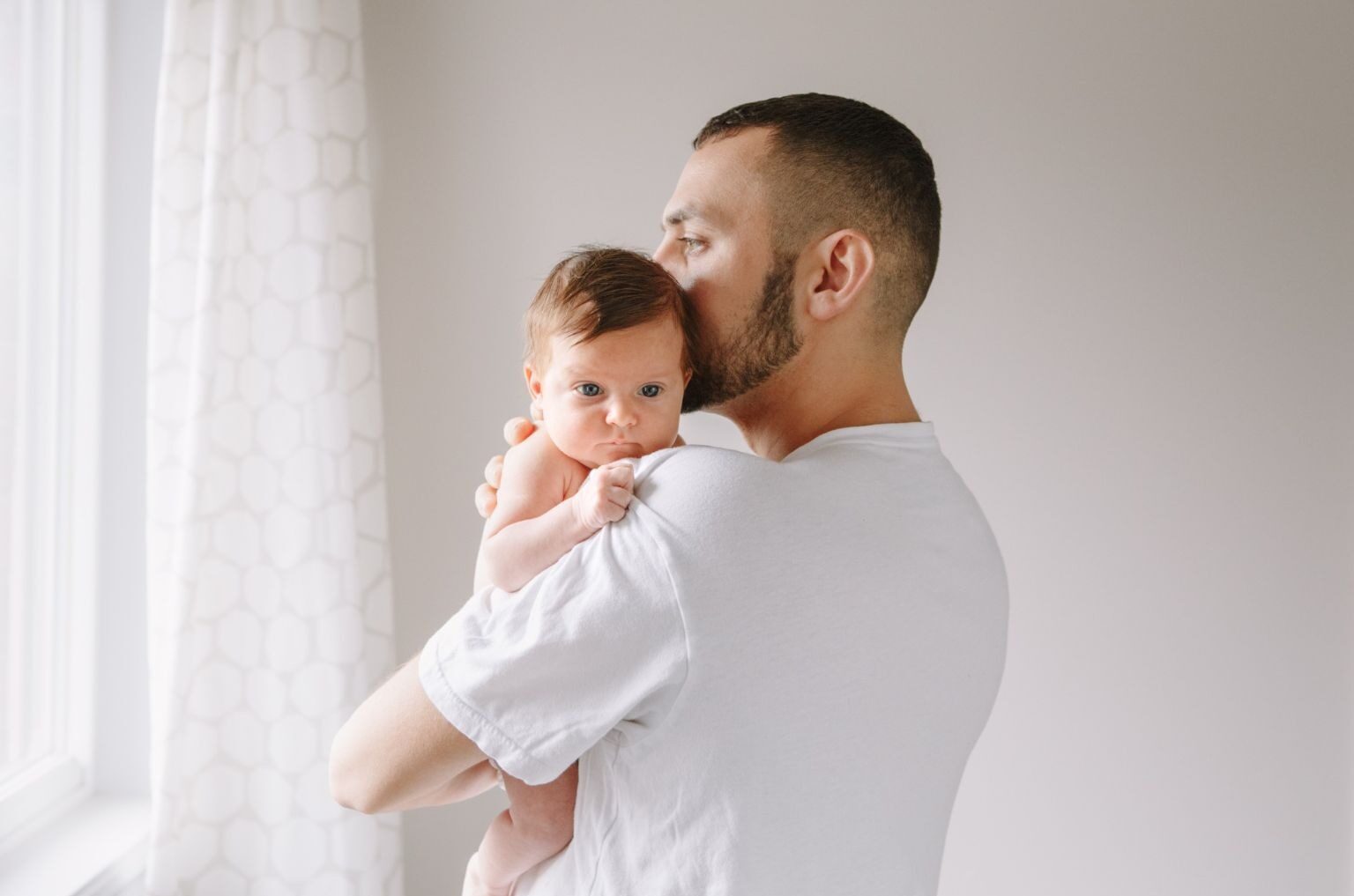 Father holding his child in front of a window