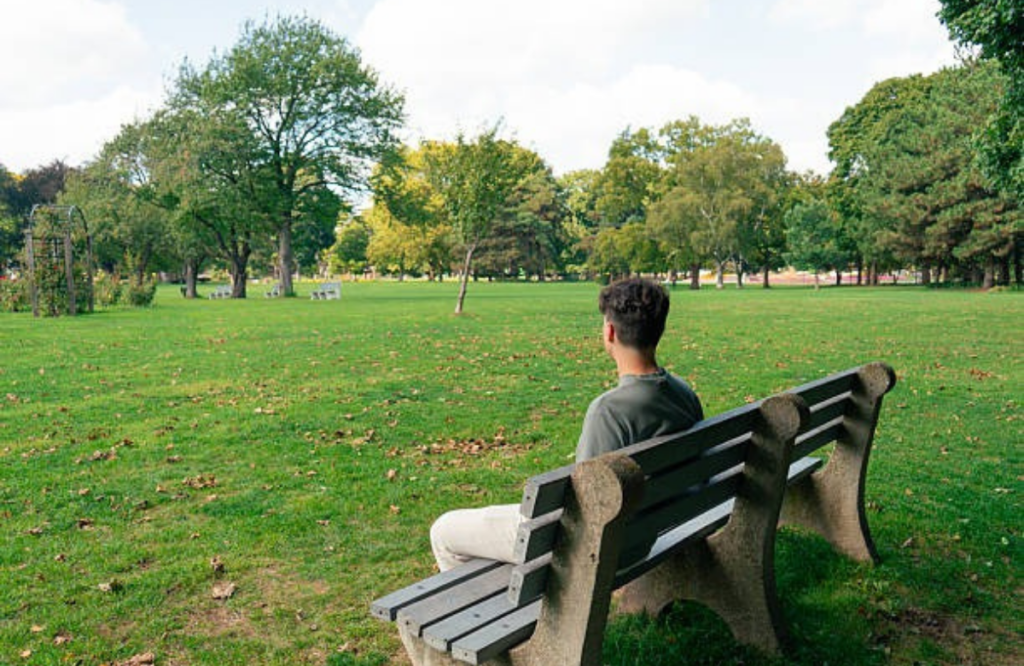 Man sitting quietly outdoors practicing mindfulness for mental wellness and stress relief