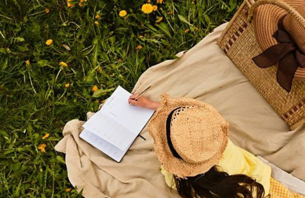 A woman outdoor journaling setup in a park supporting mental wellness and stress relief