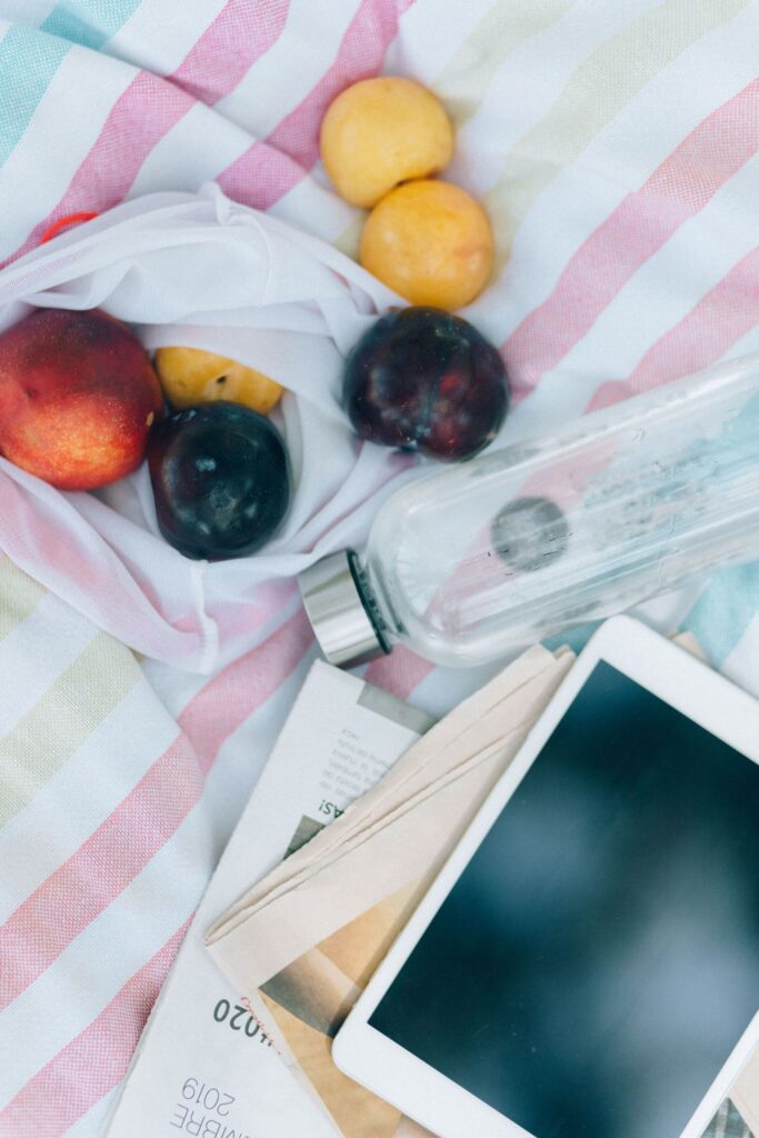 Flat lay of self-care items, water bottle, journal, healthy snack