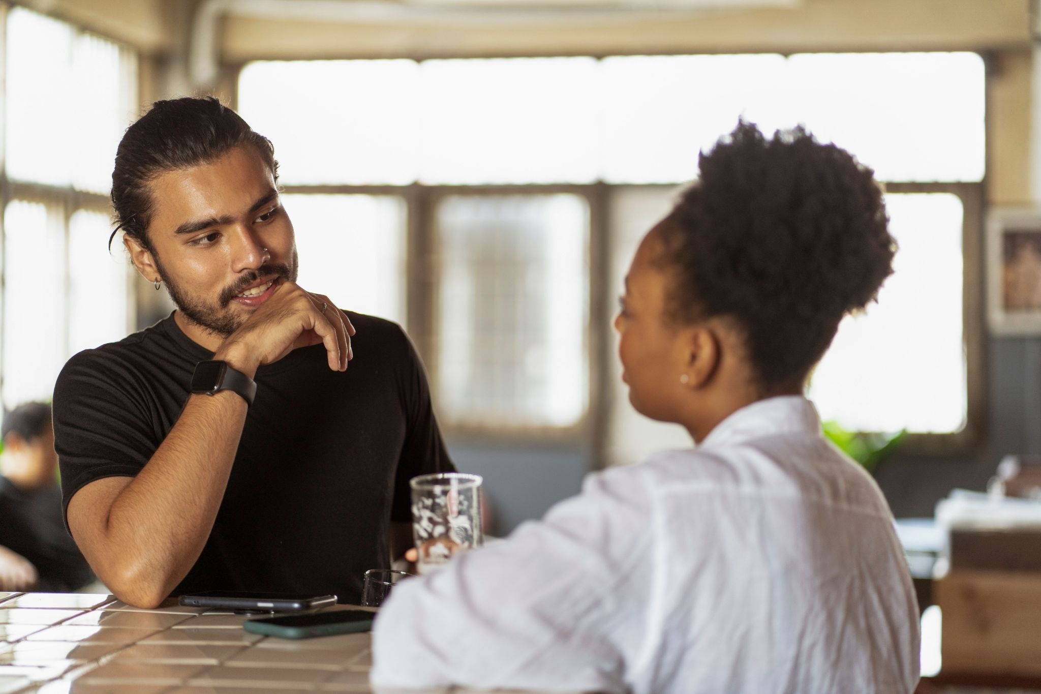Two people having a supportive suicide prevention conversation at a cafe table